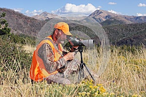 Deer hunter looking through spotting scope
