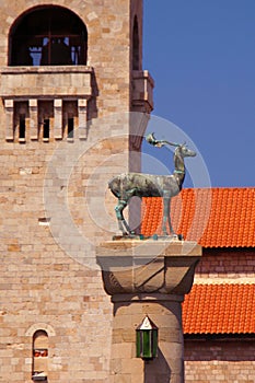 Deer statue and the bell tower of Evangelismos Church in Rhodes, Greece