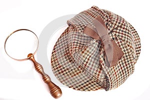 Deerstalker or Sherlock Holmes cap and vintage magnifying glass