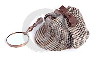 Deerstalker or Sherlock Holmes cap and vintage magnifying glass