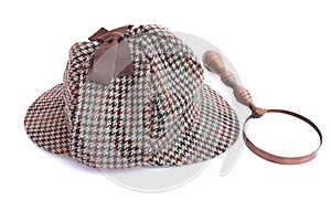 Deerstalker or Sherlock Holmes cap and vintage magnifying glass