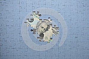 default concept, missing puzzle pieces on top of US dollar banknote, concealment of income, default concept