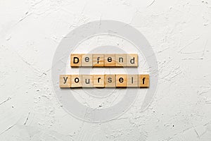 defend yourself word written on wood block. defend yourself text on cement table for your desing, concept photo
