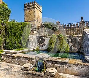 Defensive towers and fortified walls protect a secluded water garden in Cordoba, Spain