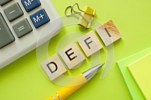 DeFi Decentralized Finance concept. Wooden letters near calculator.