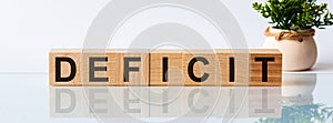 DEFICIT word written on wood block. Decision text on wooden table for your desing