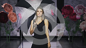 Defile beautiful girl hold umbrella catwalk model show vogue. Woman on podium.