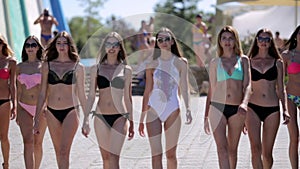 Defile of young women in bikinis in the aquapark