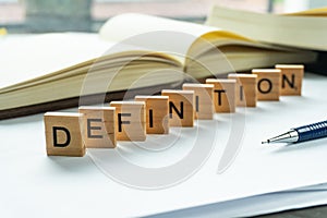 Definition print wording on wood block. on white notebook and office equipment.