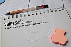 Definition of Vulnerable word with a meaning on a book. dictionary concept