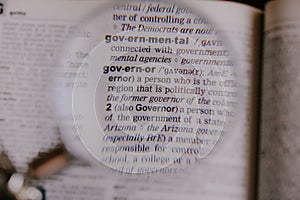 The definition of the word Governor in a dictionary, under magnifying glass, translator and language concept