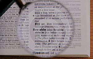 The definition of the word Liveable in a dictionary, under magnifying glass, translator and language concept