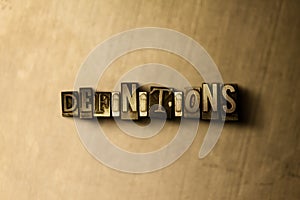 DEFINITIONS - close-up of grungy vintage typeset word on metal backdrop photo