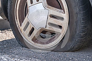 Deflated car wheel tire on wrecked car