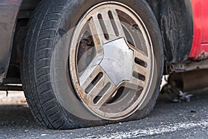 Deflated car wheel tire on wrecked car