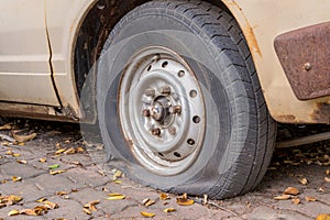 Deflated damaged tyre on car wheel