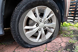 Deflated flat car tire due to rupture at the side of the wheel