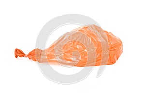 Deflated orange balloon isolated over white