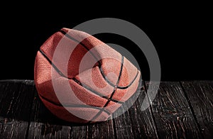 Deflated and rumpled old ball on a wooden floor photo