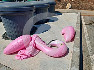 Deflated swimming pool toy neat trash can