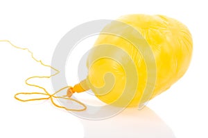 Deflated yellow balloon at a rope