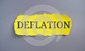 Deflation word written on yellow paper. Concept meaning decrease in the general price level of goods and services