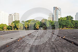 Defocus and blur image of terrace wood and water, trees and building inside. Park view in the city, natural background