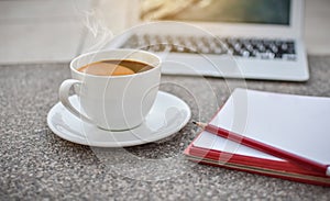 Defocus coffee cup on ground with notebook and laptop,morning,hot coffee
