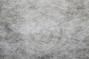 Defocus grey spunbond non-woven geotextile close-up macro. Close up. Small spots. Dirtied texture. Design, background, backdrop. photo