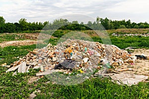 Defocus huge ruins, wreck in Ukraine, war. House after russian attack. Large garbage pile on nature green grass