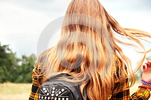 Defocus long curly blonde girl. Long hair. Back view. Rear view.