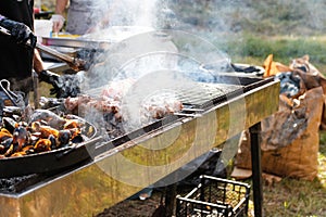 Defocus man cooking bbq meat at festival outdoor. Seafood paella. Chef grilling sausages in park outside. Concept of