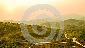 Defocus of mountain landscape and valley road with orange sky at sunset, Thailand. Background of hill landscape. Nature and