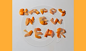Defocus New year word displayed by orange dry peel on a gray background. Decoration for New Year's Eve, concept