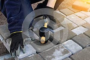 Defocus paver master. Man lays paving stones in layers. Garden brick pathway paving by professional paver worker. Hands