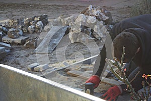 Defocus paver master. Man lays paving stones in layers. Garden brick pathway paving by professional paver worker. Worker