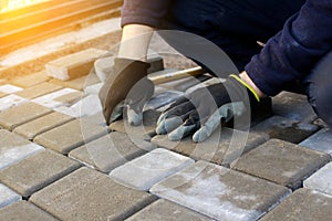 Defocus paver master. Man lays paving stones in layers. Garden brick pathway paving by professional worker. Hands of