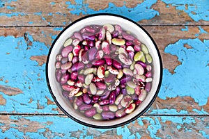 Defocus purple beans background. Plate on blue background of many grains of dried beans. Brown beans texture. Food