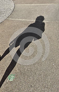 Defocus shadow silhouette of woman on gray textured asphalt surface