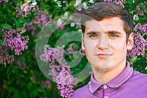 Defocus smiling caucasian man outdoors portrait. Spring people. Young men in purple shirt on nature summer background. Lilac