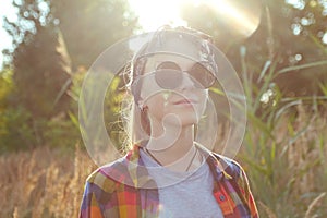 Defocus teen or preteen girl walking on nature background. Little kid girl holding bunch of pampas grass. Green meadow