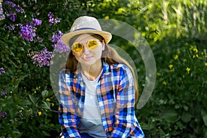 Defocus woman in yellow sunglasses. calm portrait of beautiful hipster woman in blooming bush lilac. Hipster girl