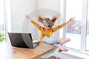 Defocus. Young business woman dancing after browsing the internet using a computer