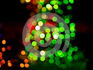 defocused abstract background with red and green bokeh light dots on a dark background