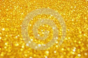 Defocused abstract colorful twinkle light background. Gold glittery bright shimmering background.