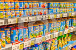 Defocused background, baby food supermarket shelves, fruit puree and porridge for feeding small children, blurred