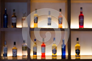 Defocused background of various alcohol bottles in a bar or restaurant. Bar advertisement mockup image