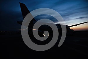 Defocused blur rear view of large aircraft airplane on the tarmac with beautiful