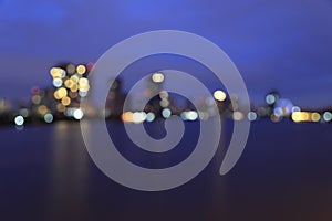 Defocused bokeh lights of Asiatique riverfront against Chao Phra