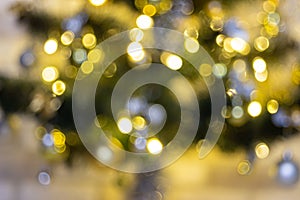 Defocused Christmas tree garland illumination. Blurred sparkling fairy background. Silver and gold lights, bokeh effect